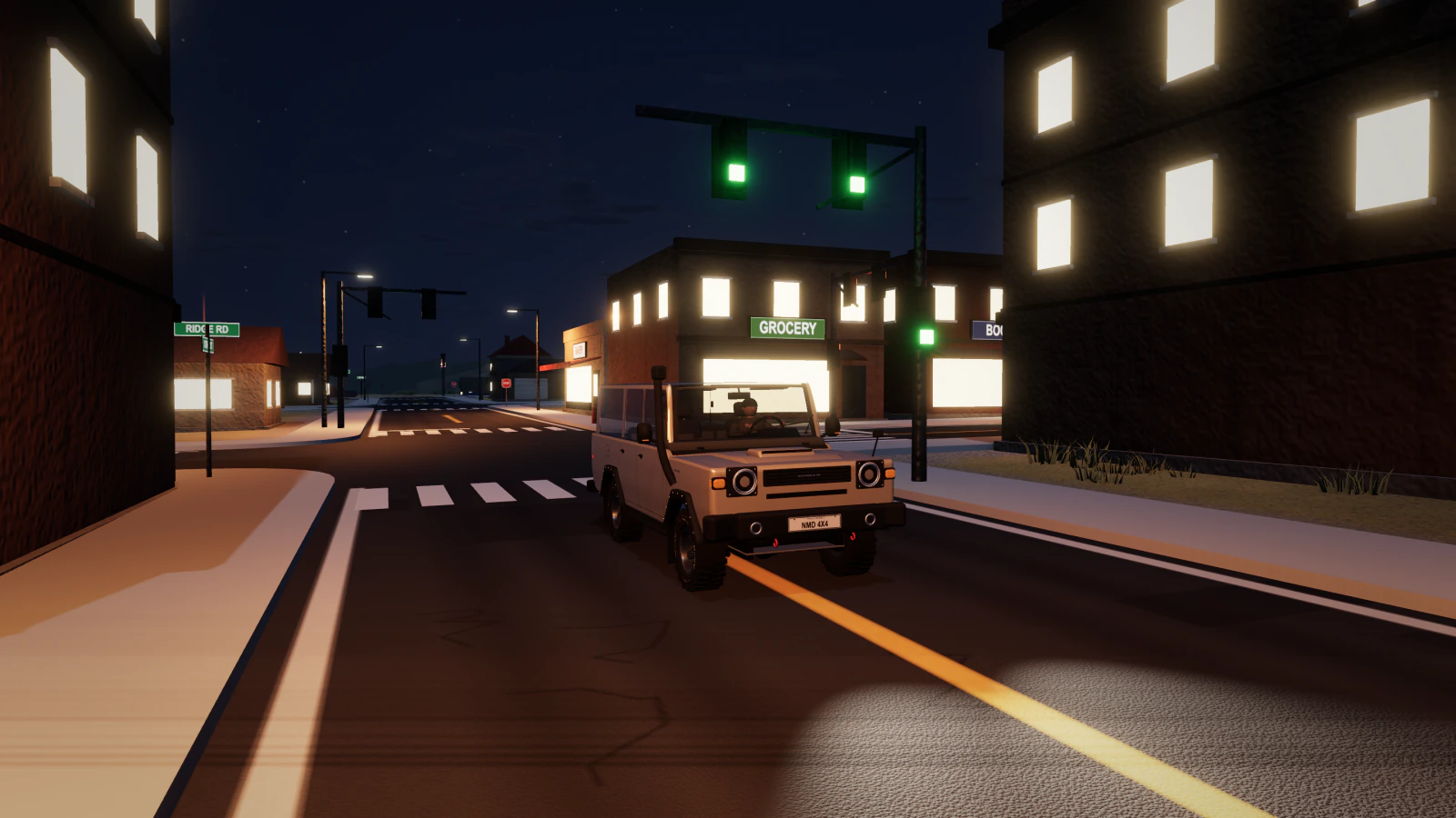 A Nomad LX expedition wagon at a town crossroads at night, under green traffic lights and lit shop windows